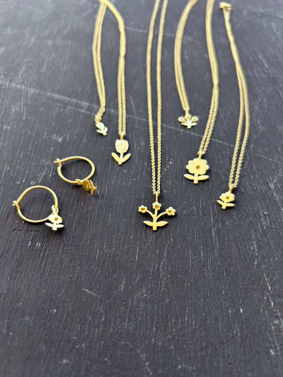 Bohemia's Bloom jewellery collection feauturing gold hoop earrings and necklaces with minimalist floral designs